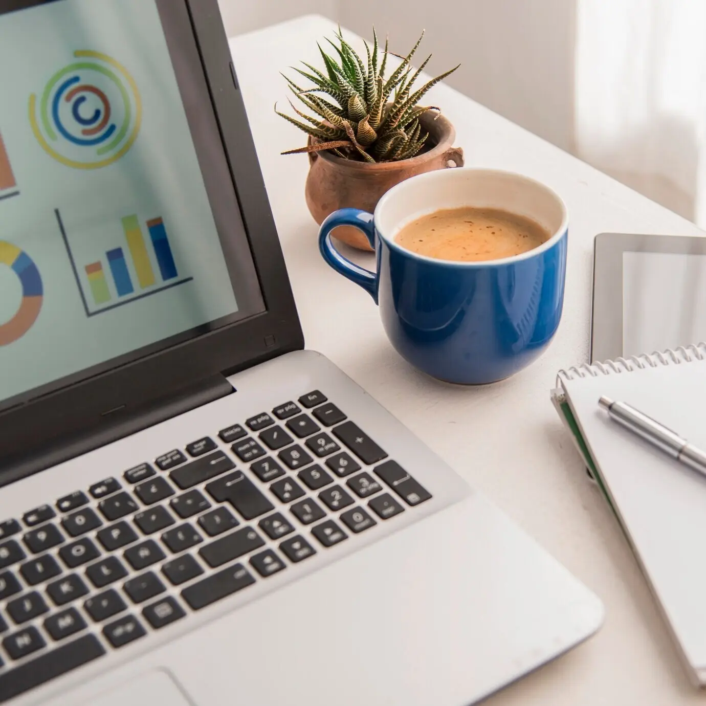 Overhead view of a laptop and an assortment of coffees.