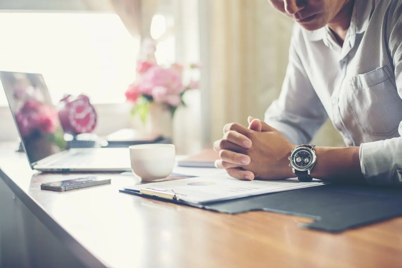 A businessman working at his desk with a cup of coffee in the office.